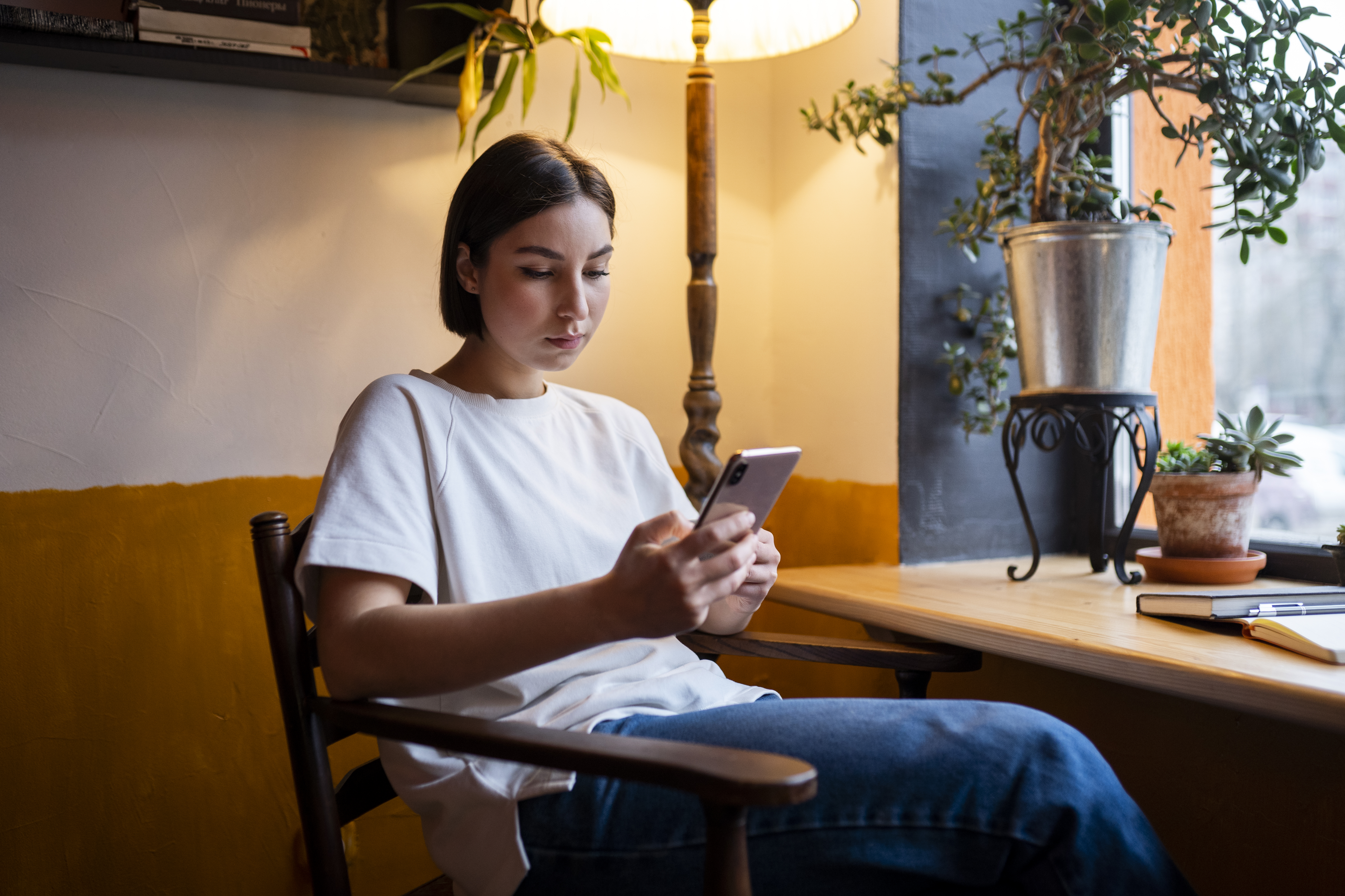 Женщина сидит на стуле и вдумчиво читает информацию на сайте