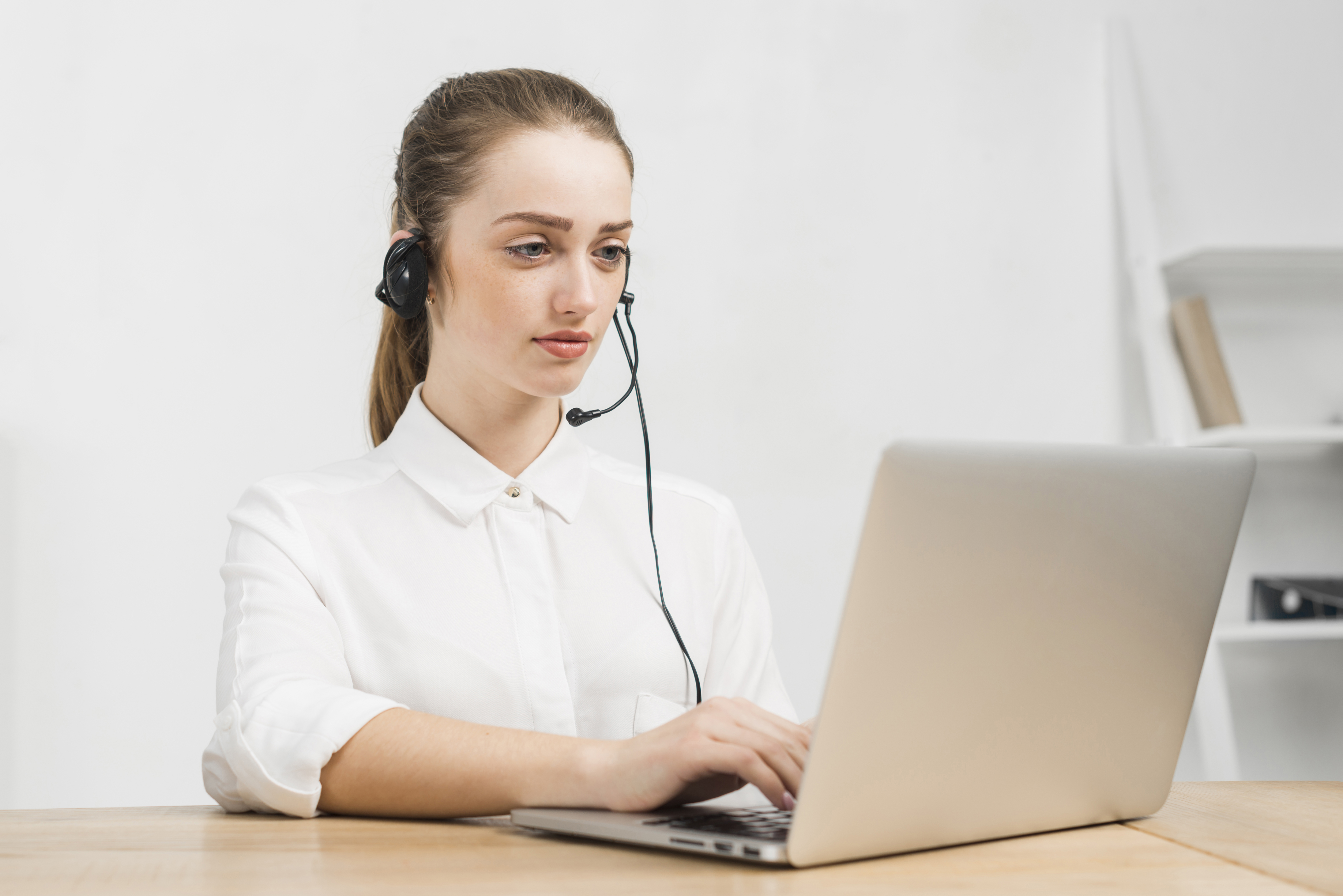 Оператор поддержки работает за ноутбуком и отвечает на звонки